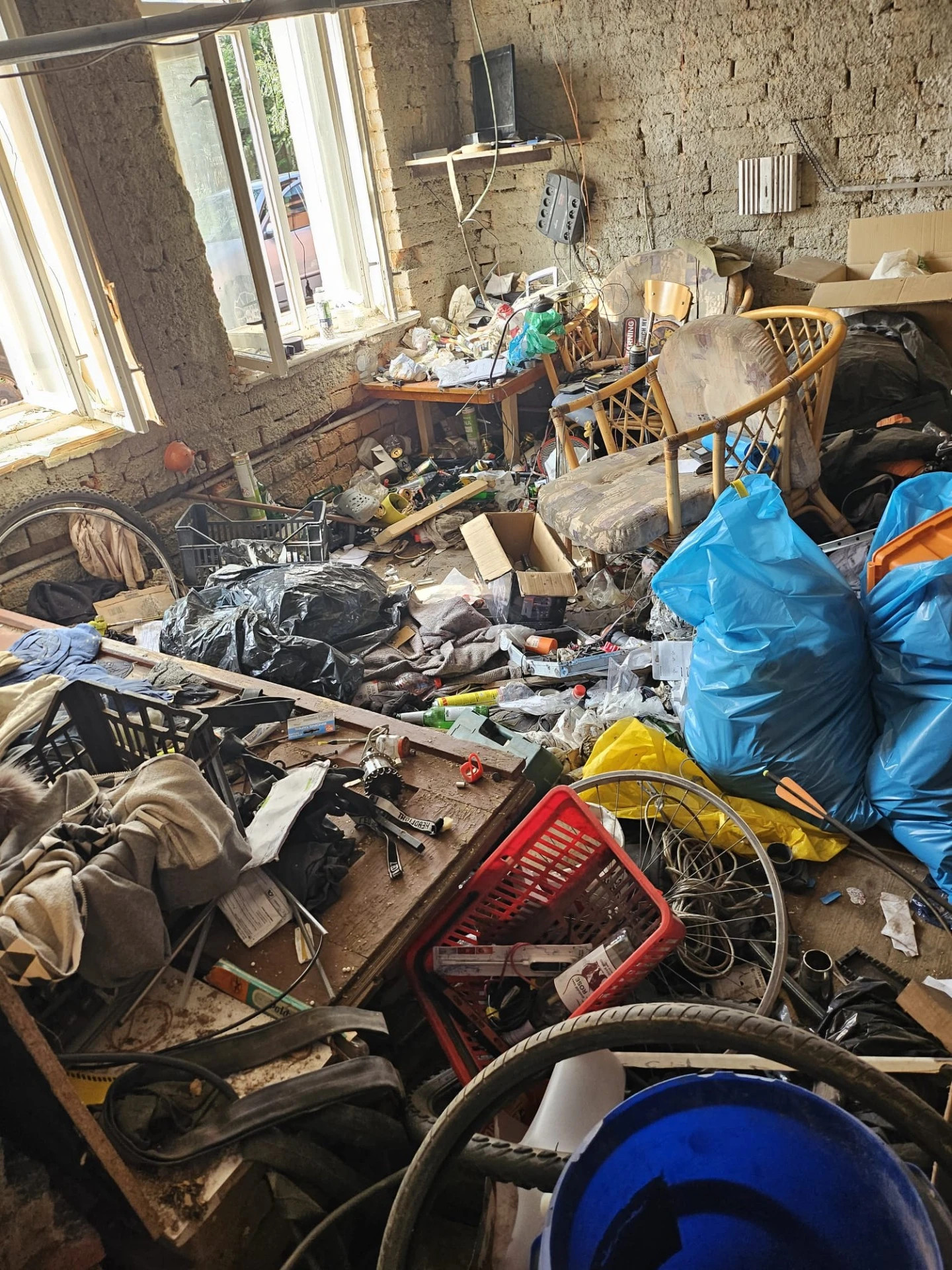 Silně znečištěný dům s nahromaděným odpadem a nepořádkem před vyklízením