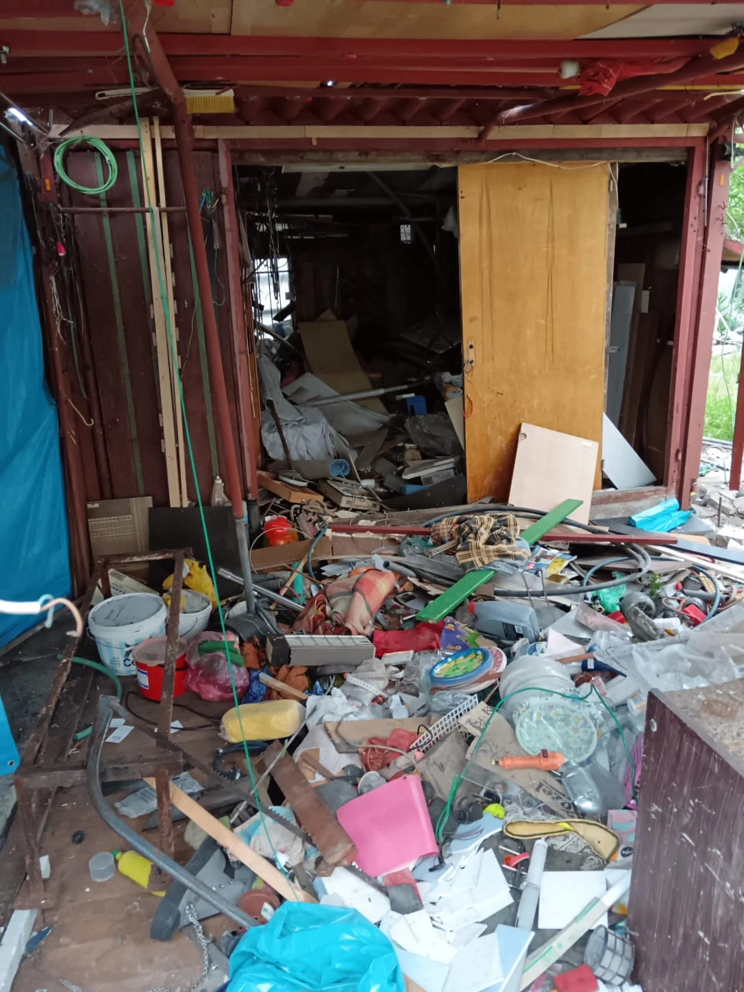 Extrémně znečištěná dílna plná odpadu před vyklízením