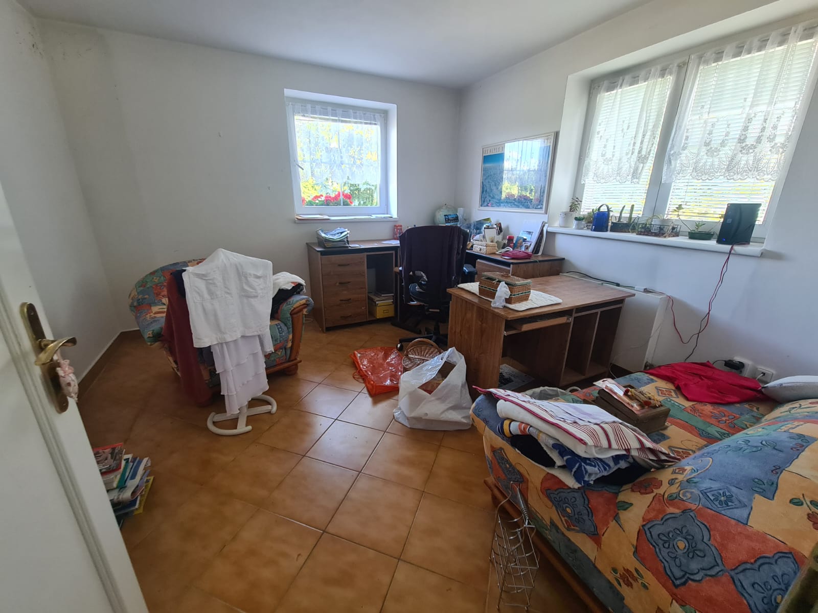 Původní stav pokoje před vyklízením – pracovní kout s nábytkem a osobními věcmi